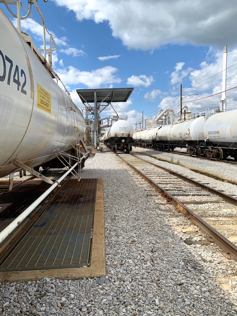 Railcar loading gangway with safety cage for chemical transport