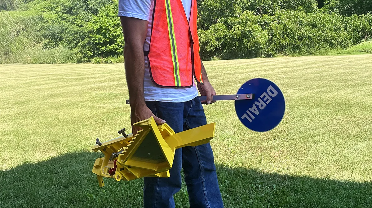 portable railroad derail being carried